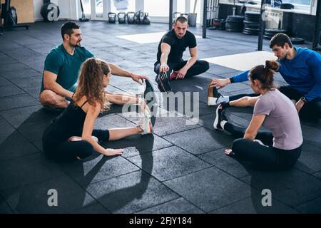 Athletes doing the seated forward bend on the floor Stock Photo