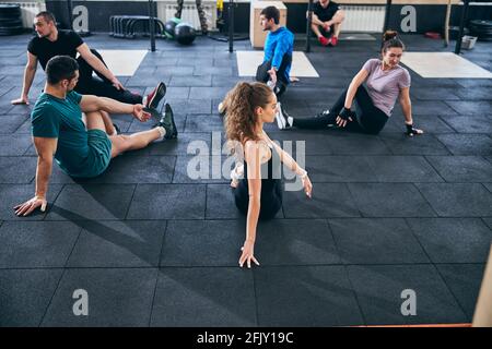 Two women and three men stretching together Stock Photo