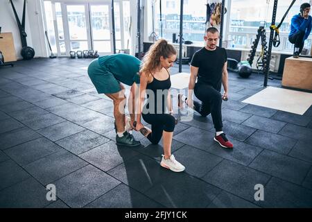 Sportspeople doing the low lunge with hand weights Stock Photo