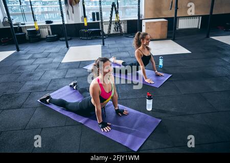 Joyous female athletes performing an abdominal stretch Stock Photo