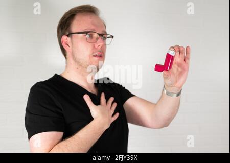 Man using an asthma spray inhaler Stock Photo
