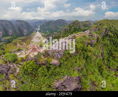 Amazing huge dragon statue at limestone mountain top near Hang Mua view point at foggy morning. Popular tourist attraction at Tam Coc, Ninh Binh Stock Photo