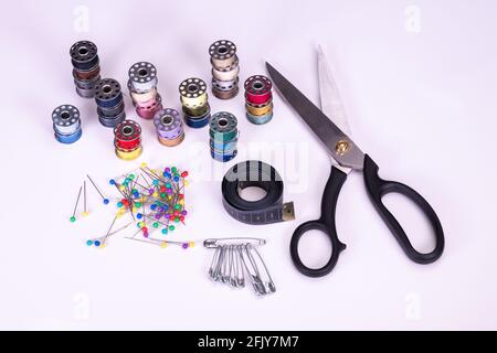 Inside a sewing kit: Colorful thread reels, pins, measuring tape and needles Stock Photo