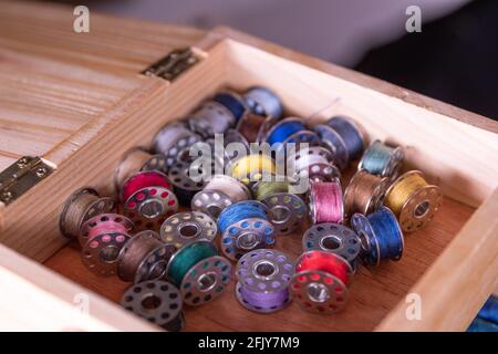 Inside a sewing kit: Colorful thread reels, pins, measuring tape and needles Stock Photo
