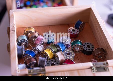Inside a sewing kit: Colorful thread reels, pins, measuring tape and needles Stock Photo