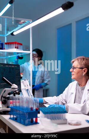 Docter Using Science Senior scientist researcher engineering vaccine with team in ...