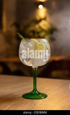Cold refreshing tonic water with ice decorated with rosemary and lemon Stock Photo