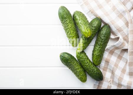Fresh green cucumbers on white table. Stock Photo