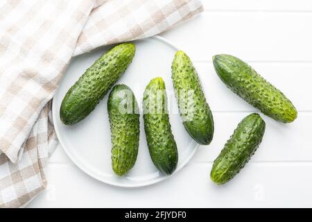 Fresh green cucumbers on white table. Stock Photo