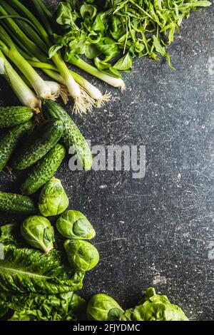 Different types of green vegetables on black table. Top view. Stock Photo