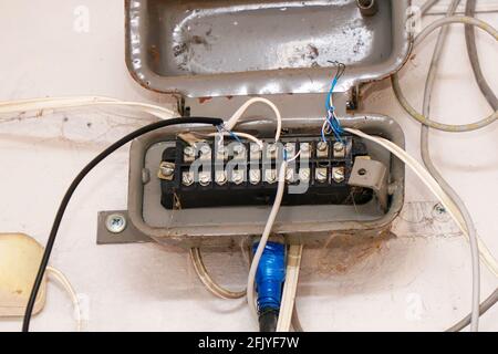 An old junction box with wires on a light wall. Soft Focus Stock Photo