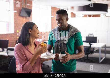 Happy diverse business colleagues on break, having coffee and snack in office Stock Photo