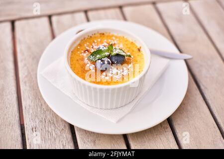 closeup french creamy dessert with caramel crust on light wooden table in summer cafe Stock Photo