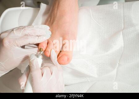 A Podiatrist doctor who takes care of a woman's toenails. Cosmetic procedures of the feet Stock Photo