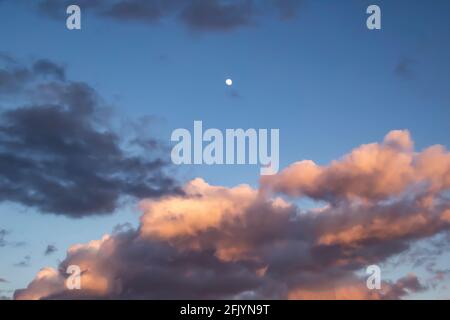 A beautiful dark clouds in the blue sky with moon against background Stock Photo