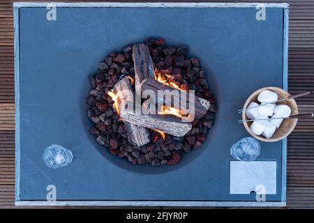 Roasting marshmallow over a gas fire while glamping Stock Photo