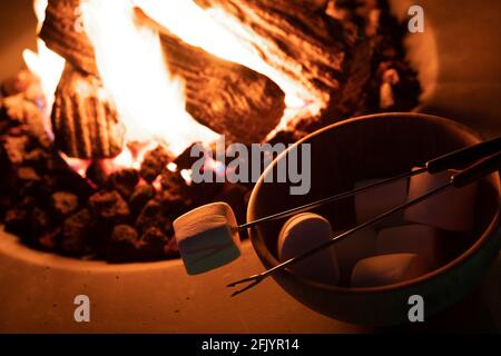Roasting marshmallow over a gas fire while glamping Stock Photo