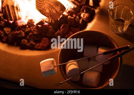 Roasting marshmallow over a gas fire while glamping Stock Photo