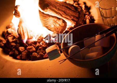 Roasting marshmallow over a gas fire while glamping Stock Photo