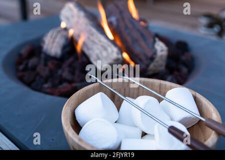 Roasting marshmallow over a gas fire while glamping Stock Photo