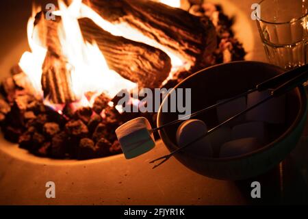 Roasting marshmallow over a gas fire while glamping Stock Photo