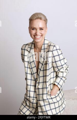 Elegant ant charismatic blond short haired businesswomen with beautiful wide smile, nice teeth and natural makeup wearing oversized linen suit with bl Stock Photo