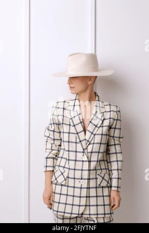 Elegant ant charismatic short blond haired and natural makeup businesswomen wearing oversized linen suit with blue stripes posing isolated in studio Stock Photo