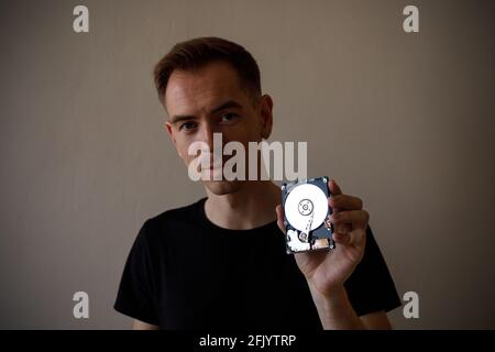 A man holding an HDD disk in his hand Stock Photo