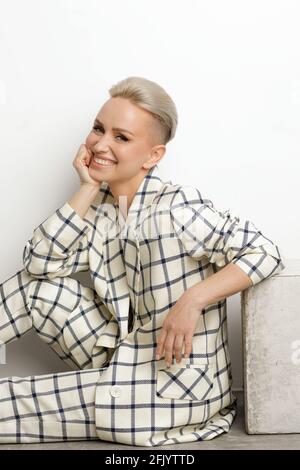 Elegant ant charismatic blond short haired businesswomen with beautiful wide smile, nice teeth and natural makeup wearing oversized linen suit with bl Stock Photo