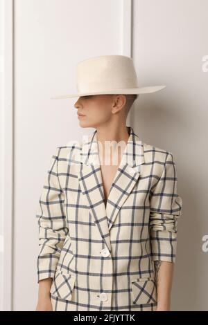 Elegant ant charismatic short blond haired and natural makeup businesswomen wearing oversized linen suit with blue stripes posing isolated in studio Stock Photo
