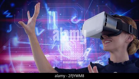 Composition of digital letters and processor over woman wearing vr headset touching screen Stock Photo