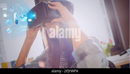 Composition of digital icons and data processing over woman wearing vr headset Stock Photo