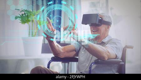 Composition of data processing over senior man in wheelchair wearing vr headset touching screen Stock Photo