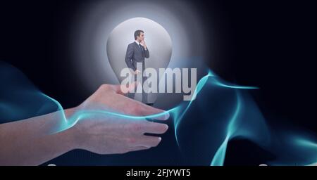 Composition of hand over businessman thinking inside light bulb over halo on black background Stock Photo
