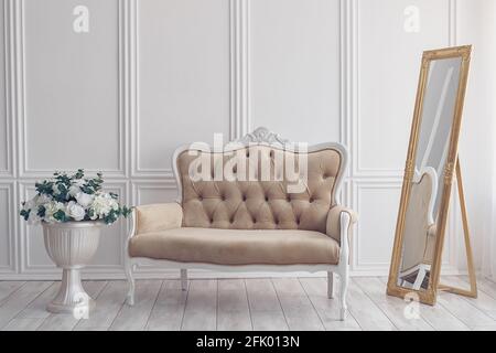 Flowers in Vase next to White Sofa Stock Photo