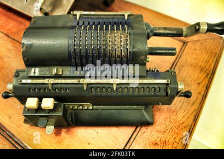 Old and vintage calculating machine on wooden table Stock Photo