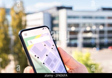 Map in phone with city street network and place pointers. Location of restaurant, hotel, taxi or ride share car in navigation mobile app. Stock Photo
