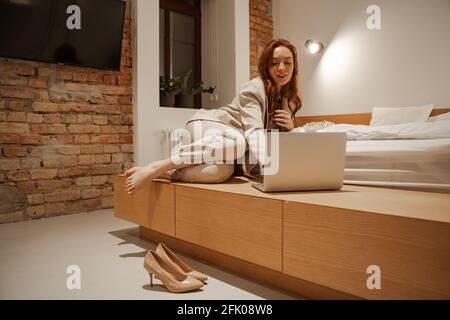 Young businesswoman watching video using laptop. Watch movies, TV shows and TV shows in the evening on your laptop while traveling in your hotel room Stock Photo