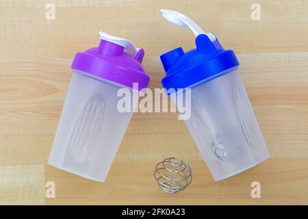 Plastic Bottle of protein shake mixer with metal shaker spiral spring ball to blend, on wooden background Stock Photo