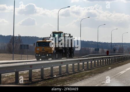 Interstate Highway Ufa - Kazan M7, Russia - Apr 23th 2021. KAMAZ truck transports a combine for harvesting in the fields Stock Photo