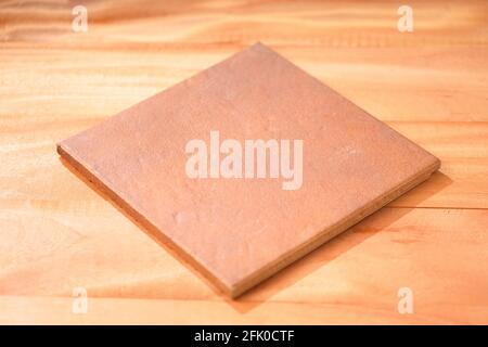 A brown colour square shaped base placed on wooden background Stock Photo