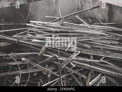 A pile of metal waste in the urn of an industrial plant. Recycling of iron waste and trash. Stock Photo