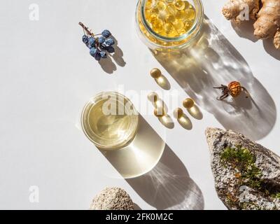 Organic natural product - oils and various dry plants for health on white background in the sunlight. Herbal alternative medicine and aromatherapy. To Stock Photo