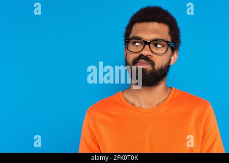 doubtful african american man in glasses isolated on blue Stock Photo