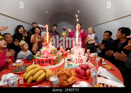 (210427) -- TAIYUAN, April 27, 2021 (Xinhua) -- Hu Zaizhong hears family members singing birthday song at his birthday banquet at Xuejiawan Village, Liulin County, Lyuliang City of north China's Shanxi Province, on April 24, 2021. Hu Zaizhong, who has just turned 100, vividly remembers his wishes at different stages of his life: having decent food and clothing in his early days, teaching as many pupils as he could in his prime age, and enjoying quality time with his family for late years. Nonetheless, Hu made a new wish before blowing the candles on his birthday cake. All members of Hu's exten Stock Photo