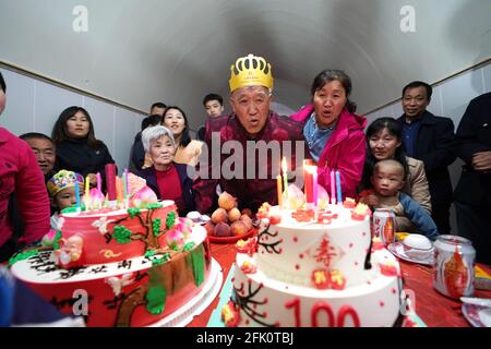 (210427) -- TAIYUAN, April 27, 2021 (Xinhua) -- Hu Zaizhong blows candles on his birthday cake at his birthday banquet at Xuejiawan Village, Liulin County, Lyuliang City of north China's Shanxi Province, on April 24, 2021. Hu Zaizhong, who has just turned 100, vividly remembers his wishes at different stages of his life: having decent food and clothing in his early days, teaching as many pupils as he could in his prime age, and enjoying quality time with his family for late years. Nonetheless, Hu made a new wish before blowing the candles on his birthday cake. All members of Hu's extended fami Stock Photo