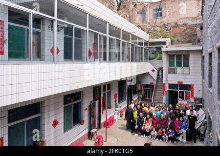 (210427) -- TAIYUAN, April 27, 2021 (Xinhua) -- Aerial photo taken on April 24, 2021 shows Hu Zaizhong posing for a family photo at Xuejiawan Village, Liulin County, Lyuliang City of north China's Shanxi Province. Hu Zaizhong, who has just turned 100, vividly remembers his wishes at different stages of his life: having decent food and clothing in his early days, teaching as many pupils as he could in his prime age, and enjoying quality time with his family for late years. Nonetheless, Hu made a new wish before blowing the candles on his birthday cake. All members of Hu's extended family flocke Stock Photo