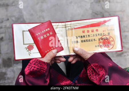 (210427) -- TAIYUAN, April 27, 2021 (Xinhua) -- Hu Zaizhong displays some of his certificates at his birthday banquet at Xuejiawan Village, Liulin County, Lyuliang City of north China's Shanxi Province, on April 24, 2021. Hu Zaizhong, who has just turned 100, vividly remembers his wishes at different stages of his life: having decent food and clothing in his early days, teaching as many pupils as he could in his prime age, and enjoying quality time with his family for late years. Nonetheless, Hu made a new wish before blowing the candles on his birthday cake. All members of Hu's extended famil Stock Photo