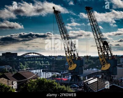 Cranes tower over the River Wear and surrounding houses in Hendon, Sunderland, a city in the north East of England. Stock Photo