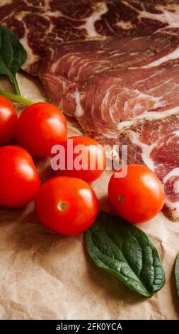 Meat slices and cherry tomatoes. Ingredients for sandwich and bruschetta Stock Photo